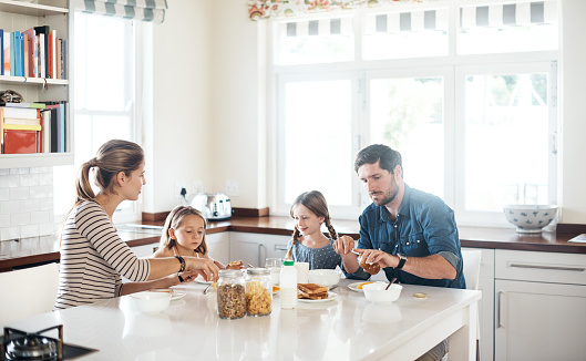 Shot of a happy family of four having breakfast together in the kitchen at home