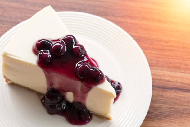 istock Blueberry cream cheesecake in white plate on wood table 854450720