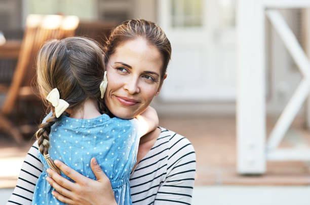 Shot of a young woman and her daughter hugging in their backyard