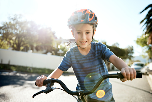 Portrait of a young boy riding his bicycle through his neighbourhood