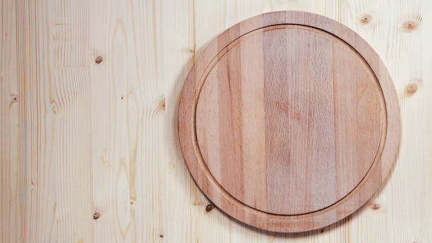 istock empty round wooden board for cutting on a wooden background 854451400