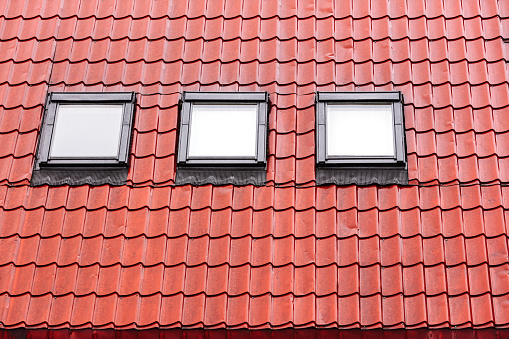 red tiled roof with skylights wet after heavy rain