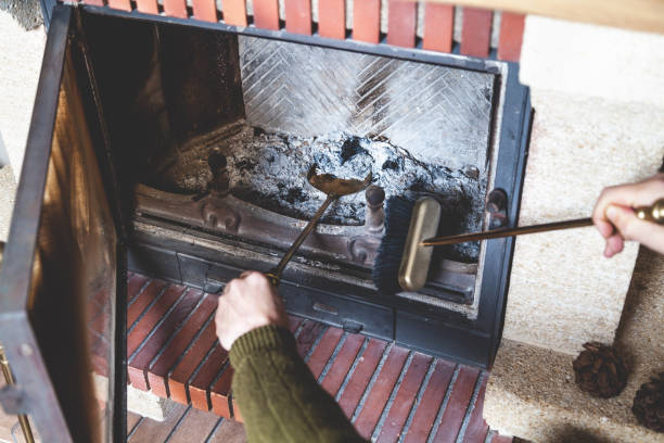 istock man cleans fireplace with brush and blades 854460898