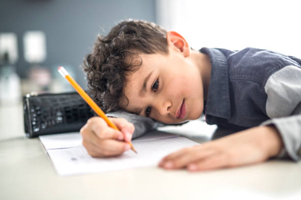 istock Cute little boy doing homework at home 854461220