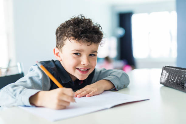 istock Cute little boy doing homework at home 854462228