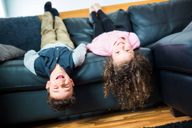 istock Pretty little girl and boy are lying on their backs on sofa 854462876