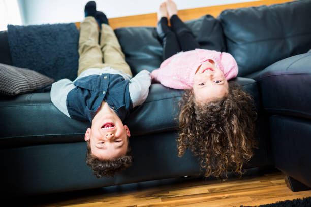 istock Pretty little girl and boy are lying on their backs on sofa 854462944