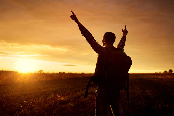 istock A traveler with a backpack lifted his hands up. 854467488
