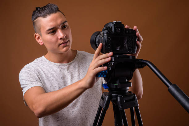 istock Studio shot of young handsome multi-ethnic man getting ready for vlogging against colored background 854468138