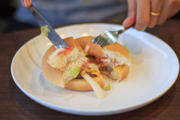 istock Close-up cutting burger Blured or blur soft focus, Holding burger cut in two halfs Blured or blur soft focus, Cheese burger, Young woman cutting burger cut in two halfs Blured or blur soft focus 854472998