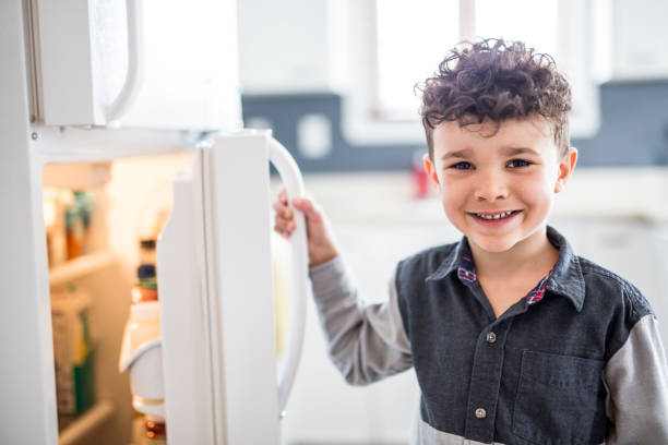istock Young white boy standing in front of open refrigerator 854473154