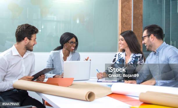 Business Partners Discussing Documents Projects And Ideas At Meeting In Office Stock Photo - Download Image Now