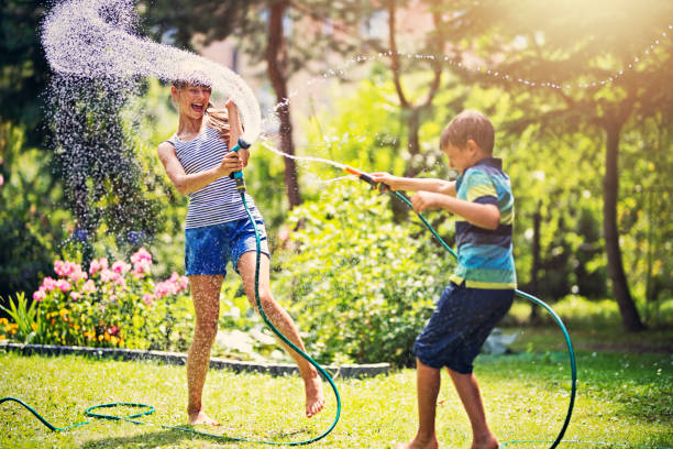 istock Children having garden hose fun in back yard 854479838
