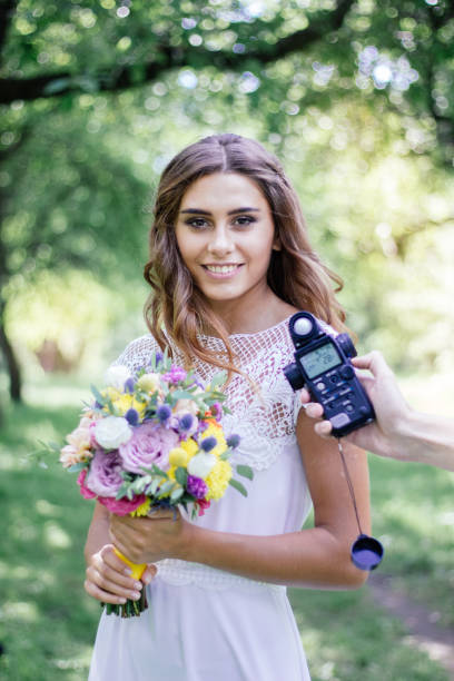 medición de luz con medidor de luz en hermosa chica fotógrafo - letter f flash fotografías e imágenes de stock