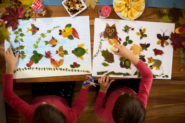 istock Sweet children, boys, applying leaves using glue 854489260