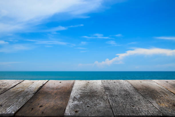 istock Blurred old wood table top on tropical beach background. 854490244