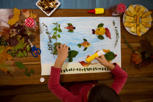 istock Sweet child, boy, applying leaves using glue 854492022