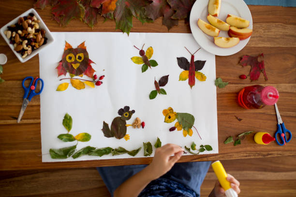 istock Sweet child, boy, applying leaves using glue 854494390