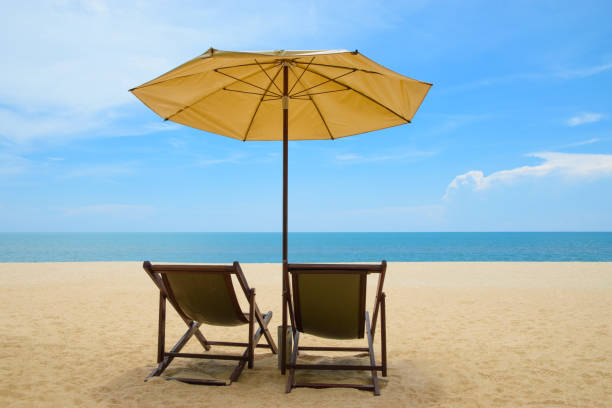 istock Beach chairs and umbrella on beautiful sand beach with cloudy and blue sky 854497998