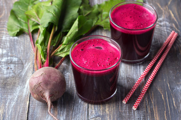 istock Fresh beet juice in glasses with a straw on a wooden background 854500016