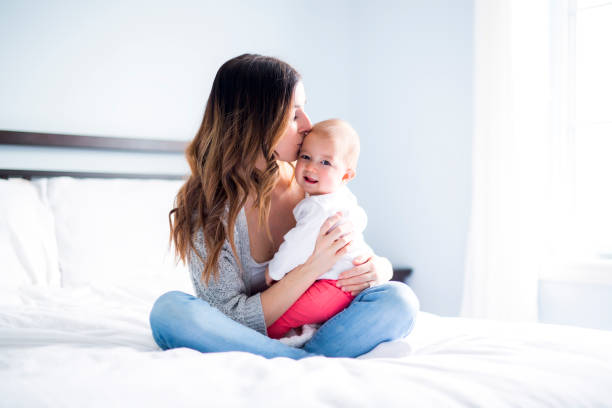 istock Mother and baby child on a white bed 854519452