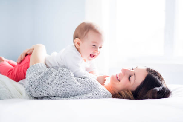 Mother and baby child on a white bed