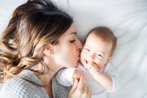 hijo de madre y bebé en una cama blanca - sheet sleeping women bed fotografías e imágenes de stock