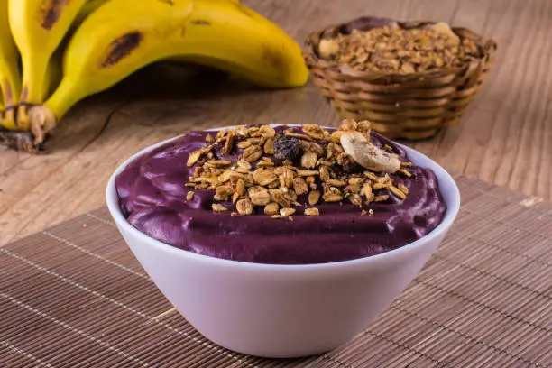 Acai with banana and granola over a wooden table