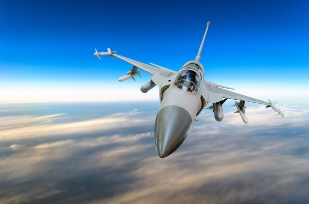istock Military fighter jet against a blue sky with a backlight from below. 854529872
