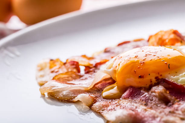 istock Ham and Eggs. Bacon and Eggs. Salted egg and sprinkled with red pepper. English breakfast 854538914