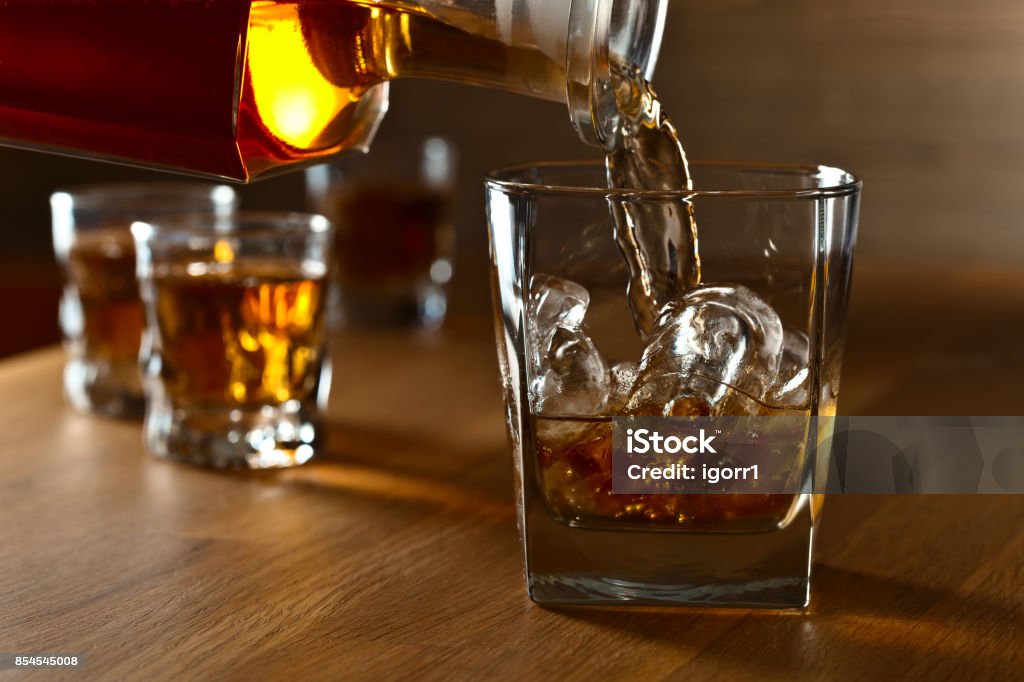 Whiskey with ice . Whiskey with natural ice on a oak table. Whiskey Stock Photo