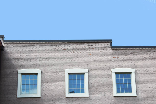 Top of brick commercial building with three windows, horizontal aspect
