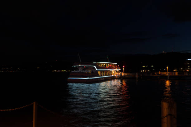 istock cruise ship with lights on at night on lake zurich with water reflections 854552876