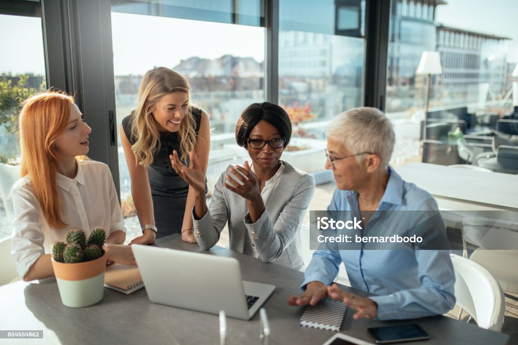 Just focus on this one thing Smiling business women working on the laptop together. Women Stock Photo