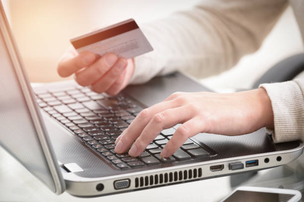 istock Womans hand holding credit card over laptop 854555338