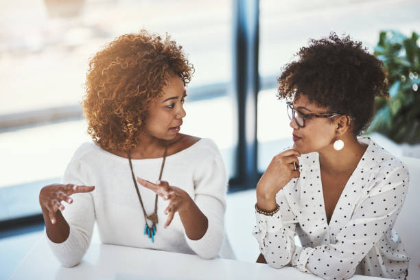 She has great ideas Shot of two young designers working in an modern office gesturing stock pictures, royalty-free photos & images