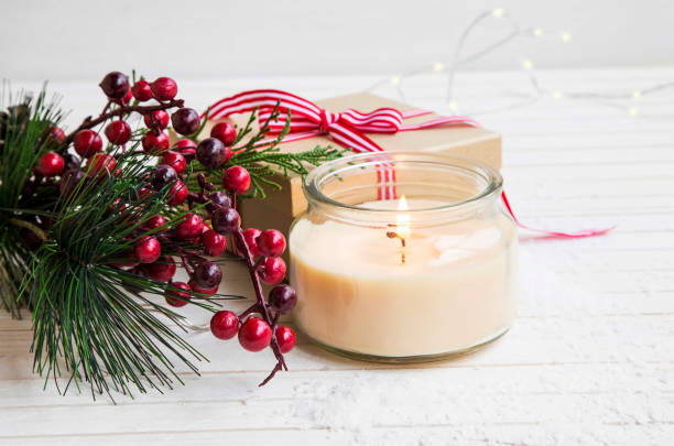 istock Festive Christmas setting with scented candle burning and fir tree branch decoration , with wrapped gift , seasonal winter holiday concept greeting or card 854560110