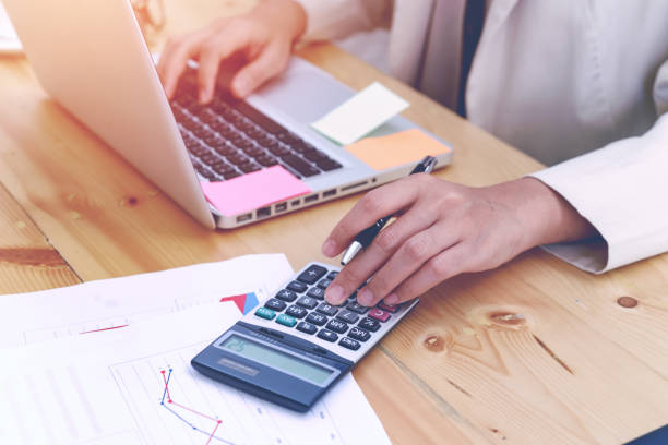 istock business woman hands working using calculator with financial data analyzing hand calculate writing and counting in office. Workplace strategy Concept. 854560506