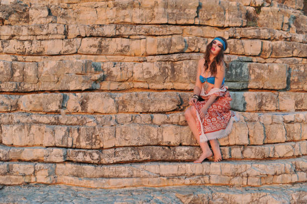 istock Young bikini girl posing on the rocks 854565396