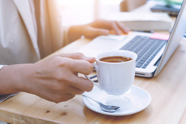 istock close up woman hand hold coffee in office,business document and laptop computer notebook. 854566774