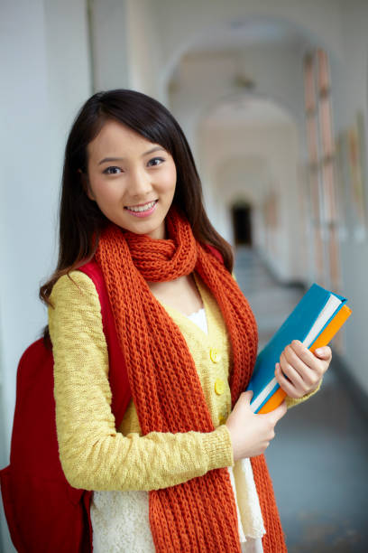 istock pretty young college student holding book smile at camera 854567014