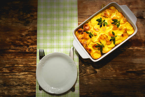 Freshly cookedSerbian potato and mixed minced meat moussaka meal in white casserole with basil leaves on top.