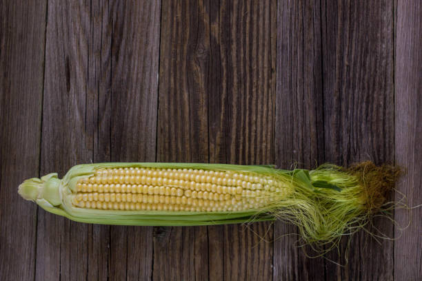 istock Fresh corn on cobs on rustic wooden table, closeup, top view, copy space 854582288