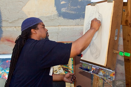 June 16, 2012 - Philadelphia, PA, USA:  An African-American artist draws a new art work  to sell at an outdoor African-American Art Expo in Philadelphia, Pennsylvania.\