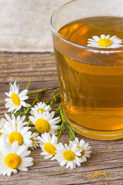istock Cup of tea with chamomile flowers on rustic wooden background 854583844