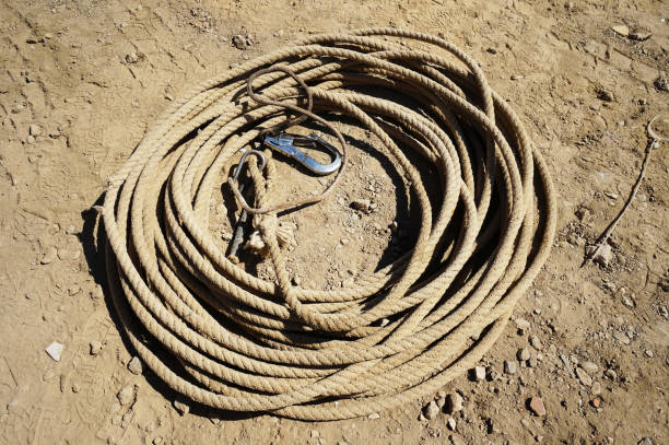 istock Building with Cranes, rope with hook lying rolled up on the ground 854588572