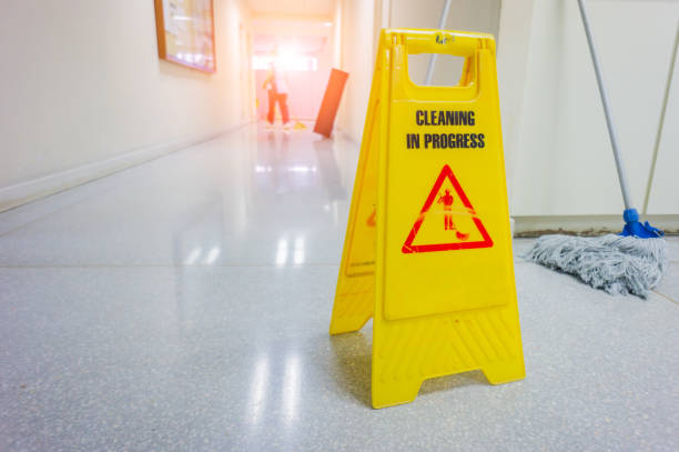 istock caution wet floor warning sign with blurred worker mopping floor 854589872