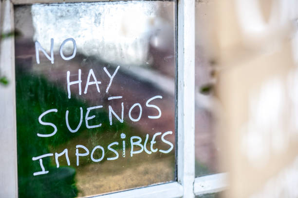 istock Optimist phrase written over old windows glasses in spanish 854590120