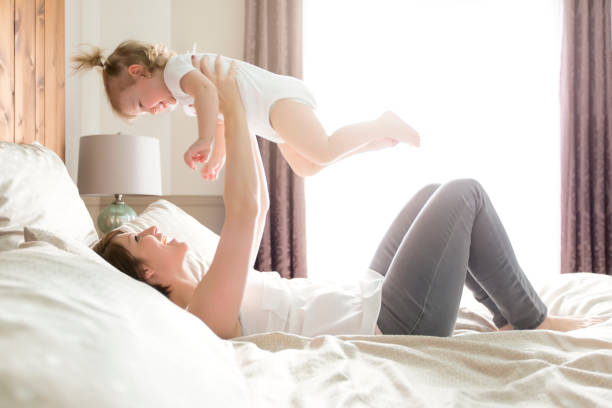 istock Young happy mother with baby on bed 854593424