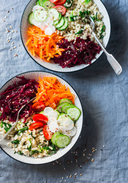 istock Fall vegetarian buddha bowl. Bulgur, spinach, beets, carrots, cucumbers, tomatoes, daikon - balanced healthy eating lunch. On a blue background, top view. Comfort autumn winter food 854600610